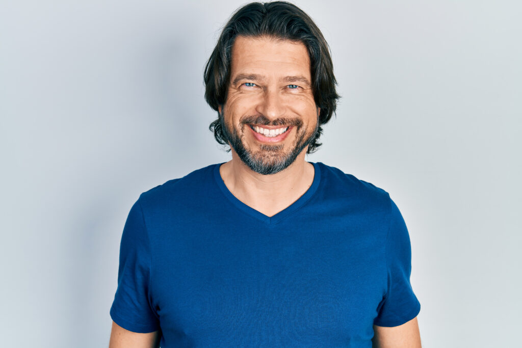 Middle age caucasian man wearing casual clothes looking positive and happy standing and smiling with a confident smile showing teeth