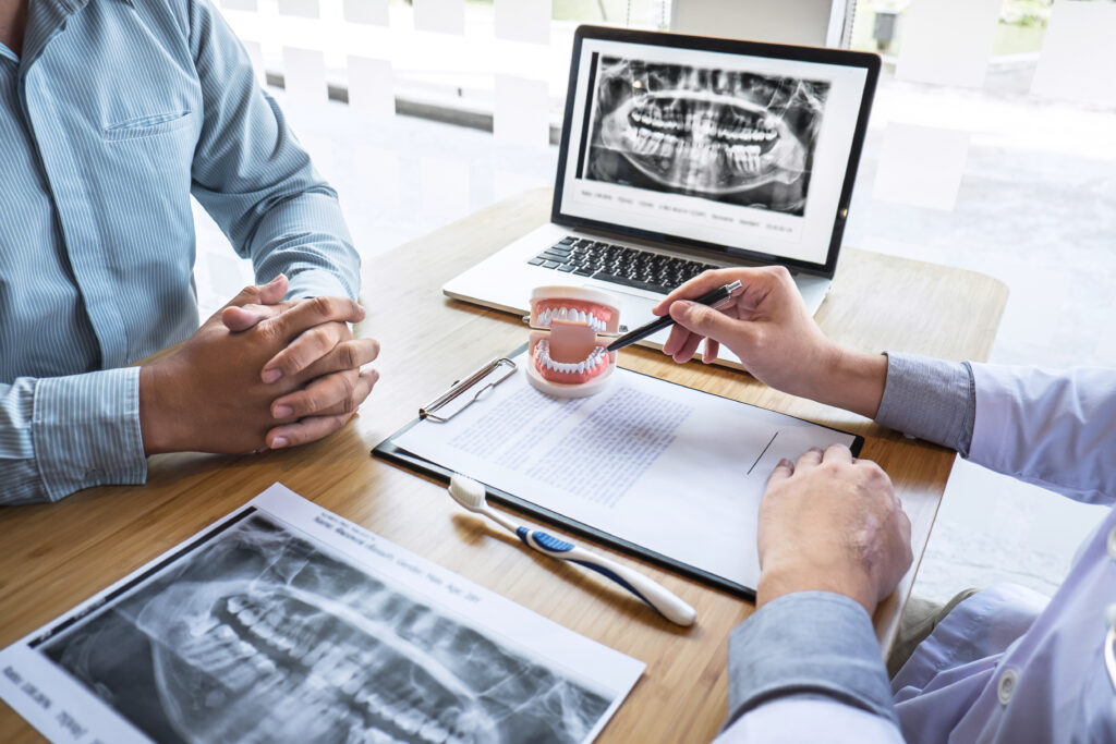 Professional Dentist showing jaw and teeth x-ray photograph before oral surgery